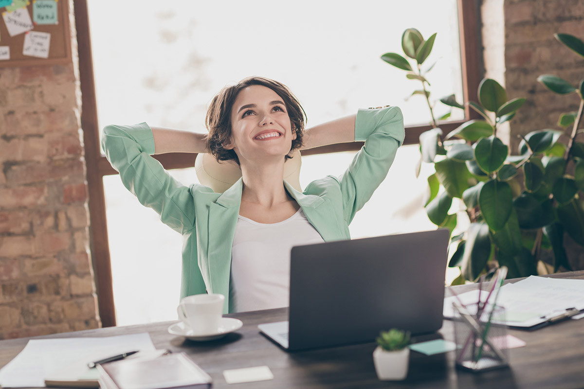 Mujer frente a laptop sonrie porque toma inositol para la salud mental