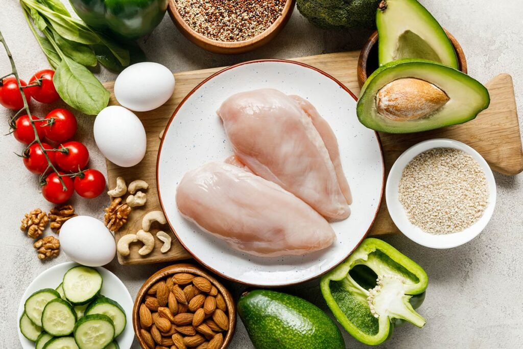 Alimentos nutritivos como pollo, huevo, aguacate, almendras muestran cómo es una alimentación saludable para embarazadas.