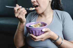 Mujer comiendo alimentos adecuados para cada fase de su ciclo menstrual logra equilibrio hormonal.