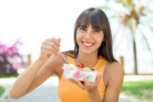 Mujer feliz disfrutando de una comida saludable como parte de su dieta para endometriosis.