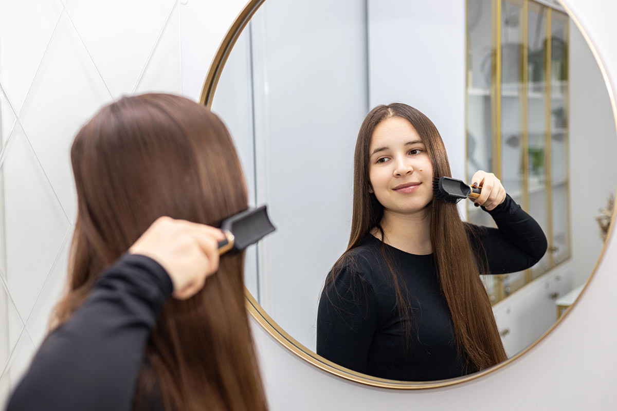 Mujer feliz con cabello saludable por el uso de ácido hialurónico