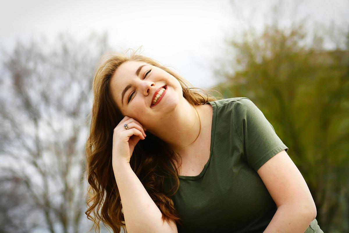 mujer sonriendo al aire libre reflejando bienestar gracias a los beneficios de los suplementos con zinc, selenio y magnesio.