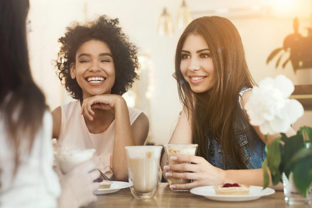 Un grupo de mujeres platicando y sonriendo, con alivio y bienestar porque saben para qué sirve el magnesio en las mujeres.
