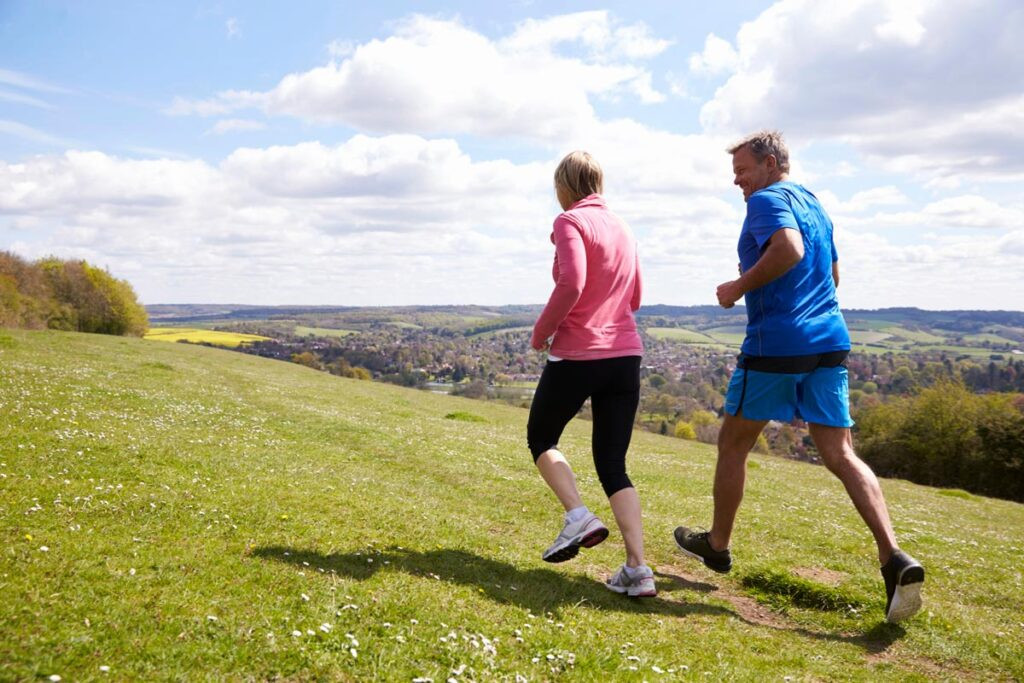 Pareja haciendo ejercicio con energía y vitalidad gracias a que saben qué vitaminas se deben tomar después de los 50 años.