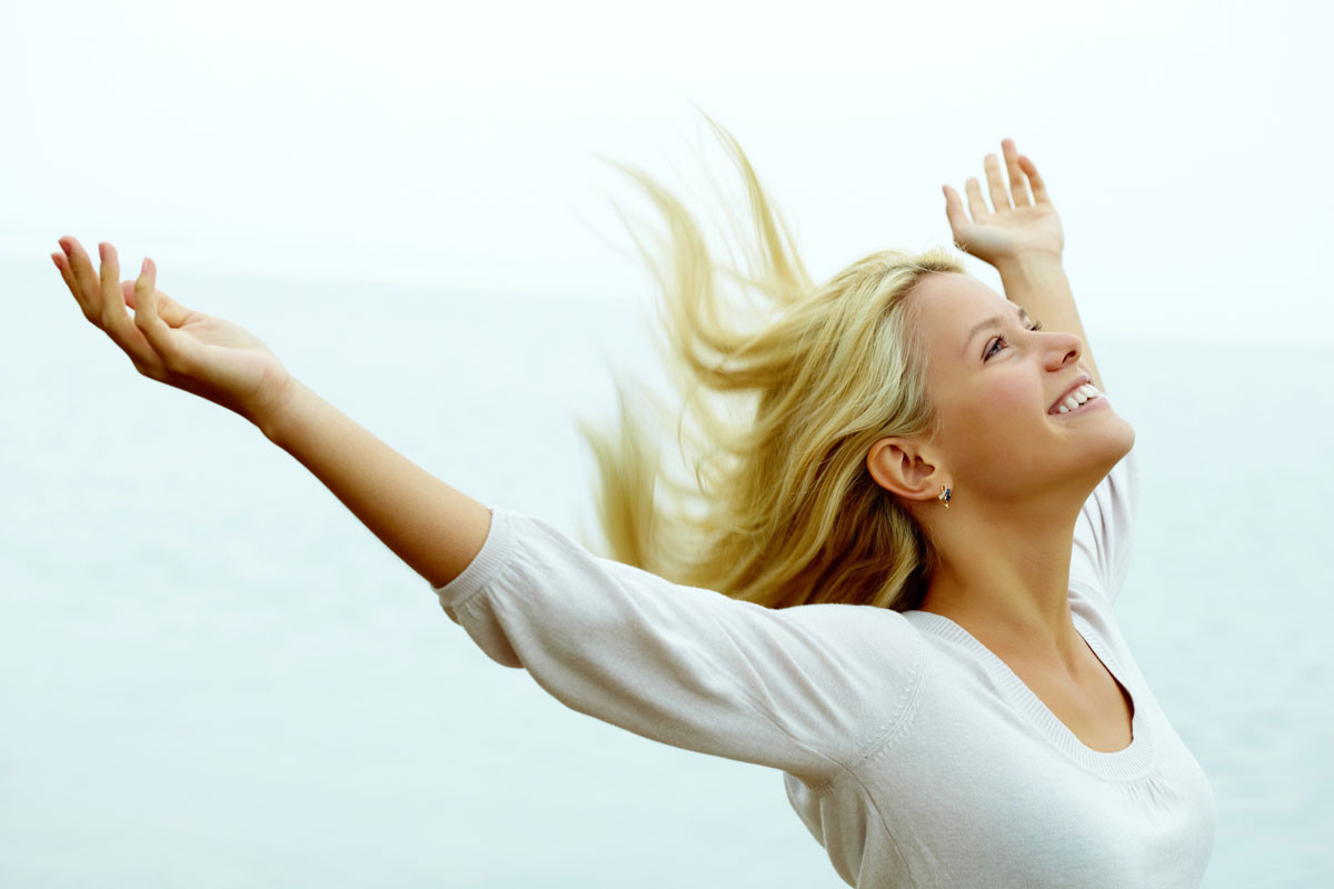 Mujer sonriente haciendo actividad ligera, representando la vitalidad recuperada gracias a las vitaminas para hipotiroidismo.