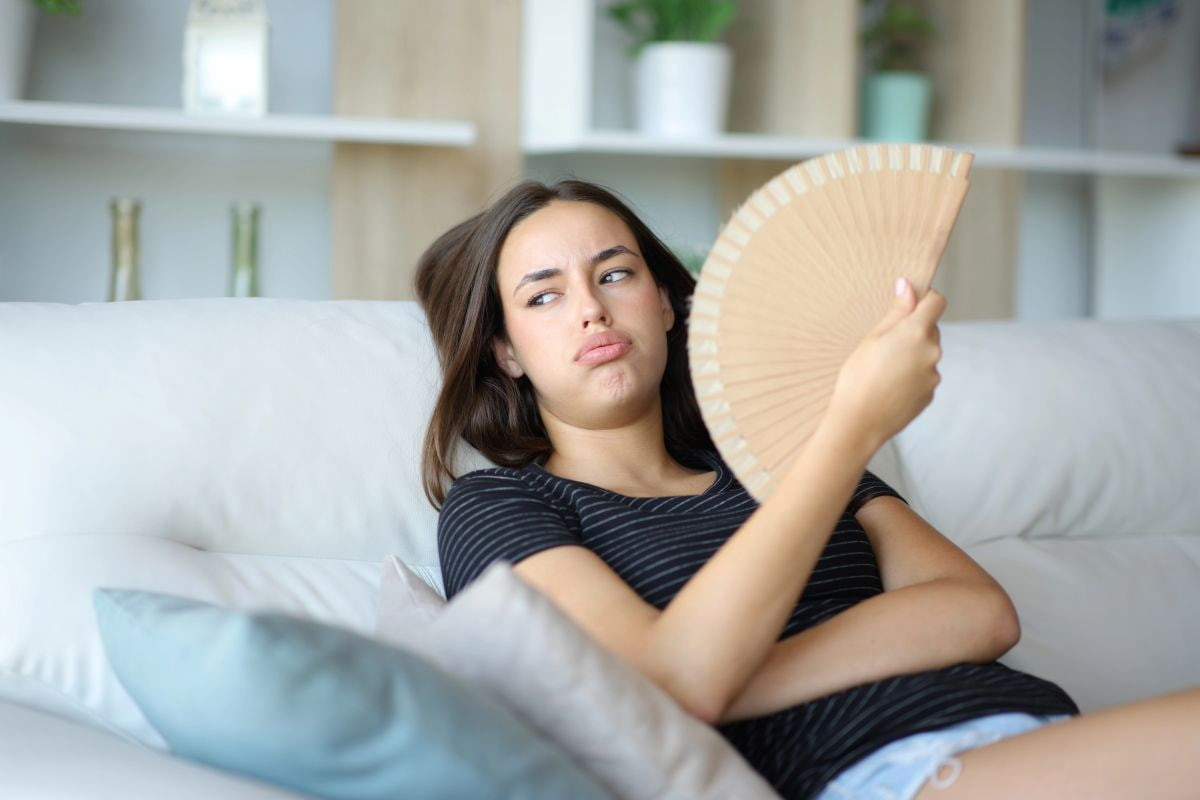 Mujer con sofocos e irritabilidad por menopausia temprana buscando soluciones naturales para reducir su malestar.